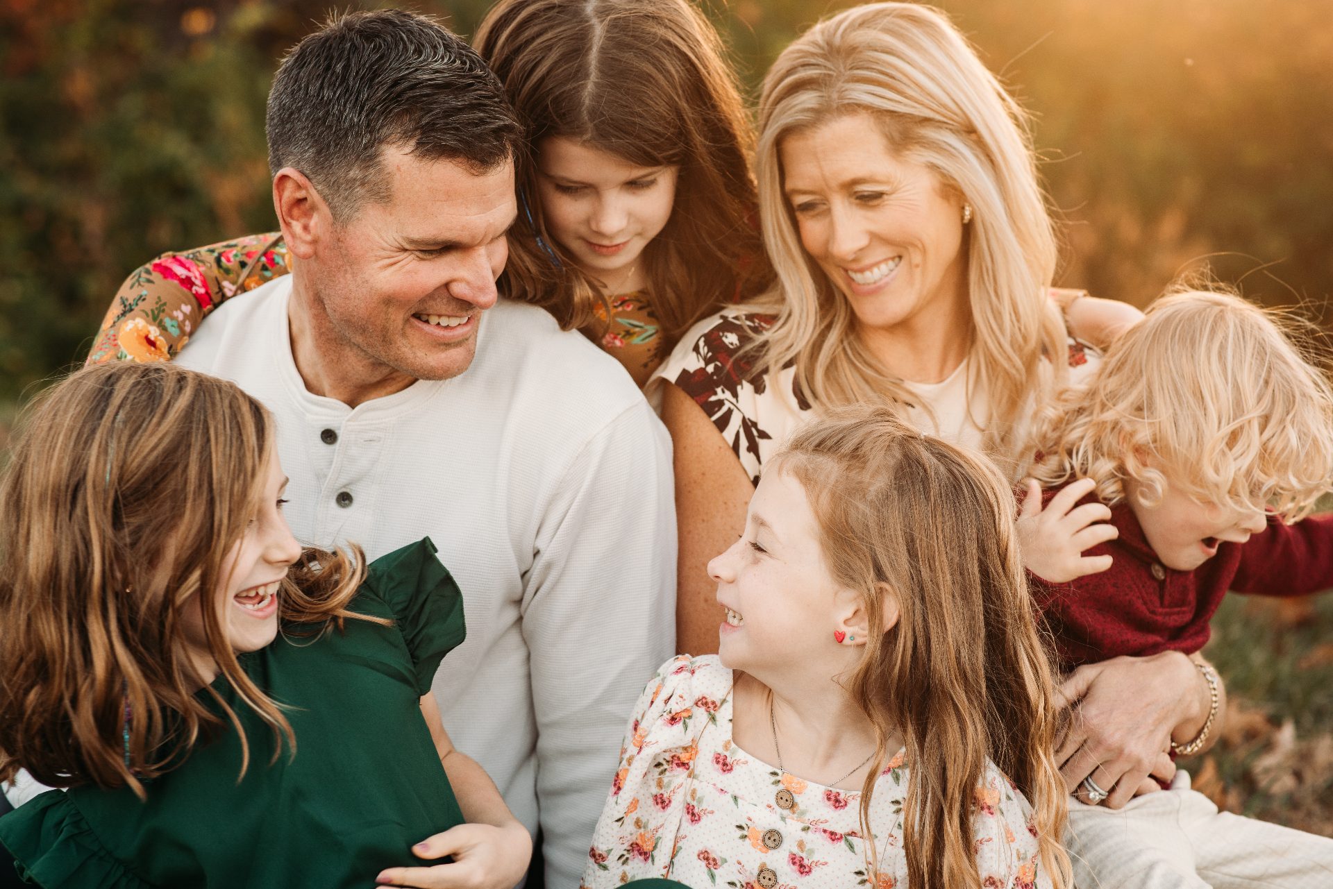 Kansas City family of six laughing together in warm golden-hour autumn light, photographed by Rachel Cherry Photography